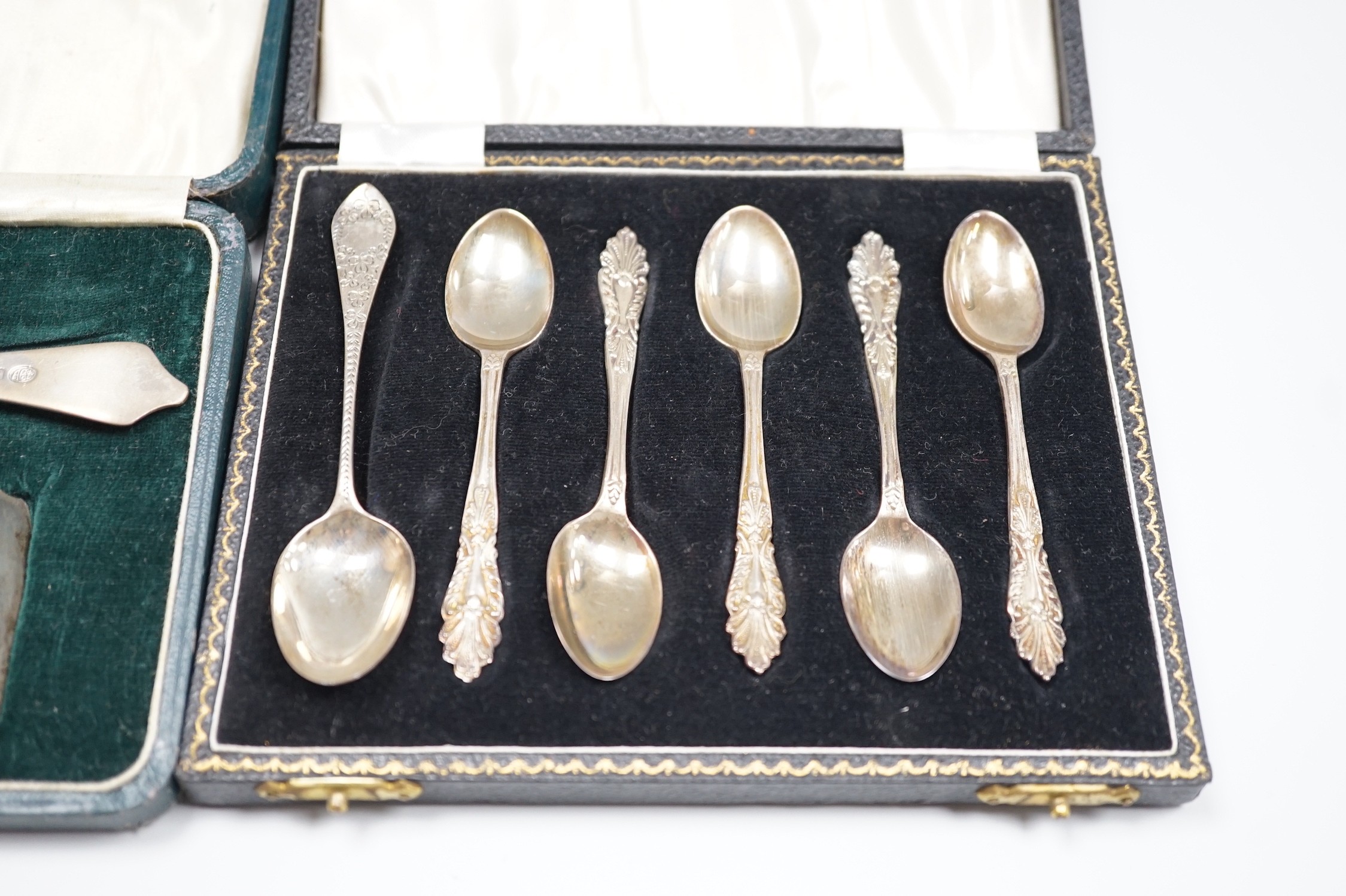 A pair of George V silver napkin rings, Edward Barnard & Sons Ltd, London, 1916 and two cased sets of silver cutlery, coffee spoons and spoon and pusher.